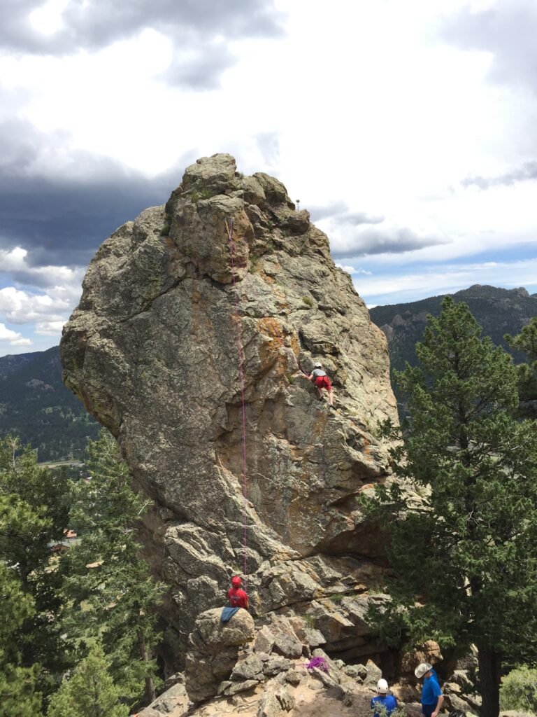 Taylor climbing a massive rock